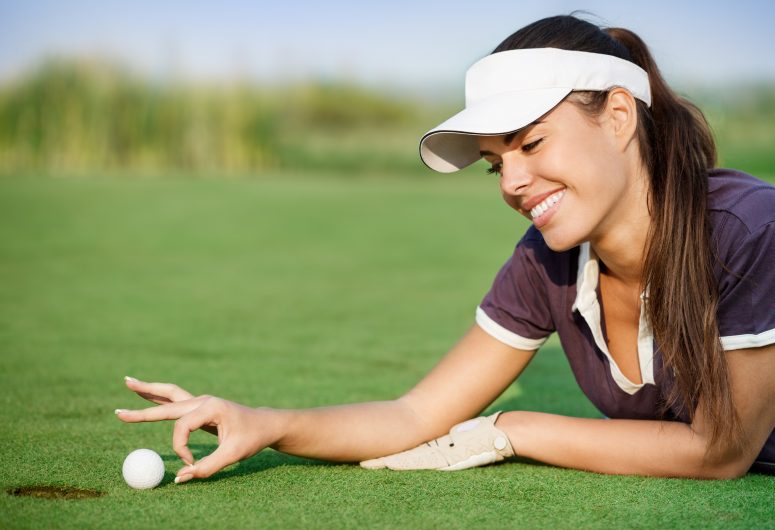 Woman pushing golf ball